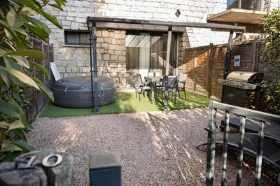 a backyard with a grill and a table and chairs at N10 Maison T2 climatisé avec jacuzzi privé in Ajaccio