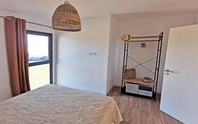 a bedroom with a bed and a window and a mirror at Résidence Petra Paolina in Folelli