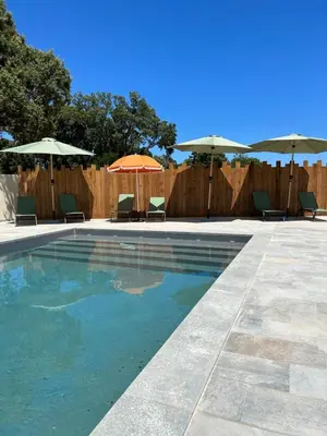 a swimming pool with chairs and umbrellas at Résidence Petra Paolina in Folelli