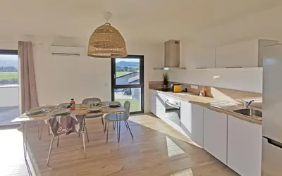 a kitchen with a table and chairs in a room at Résidence Petra Paolina in Folelli