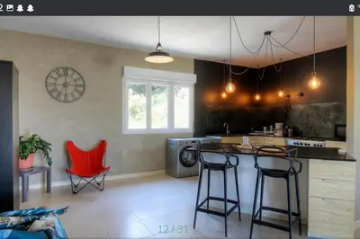 a kitchen with two red chairs and a counter top at Maison CALM2 in Viggianello