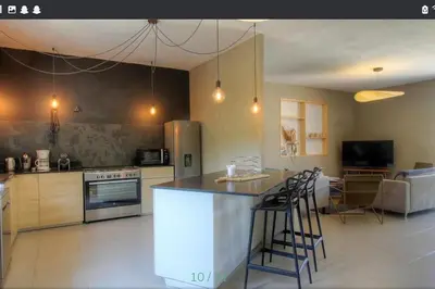 a kitchen with a counter and a bar with stools at Maison CALM2 in Viggianello