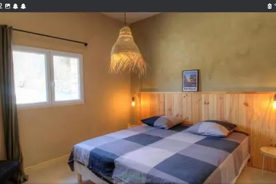 a bedroom with a bed with a blue and white checkered blanket at Maison CALM2 in Viggianello
