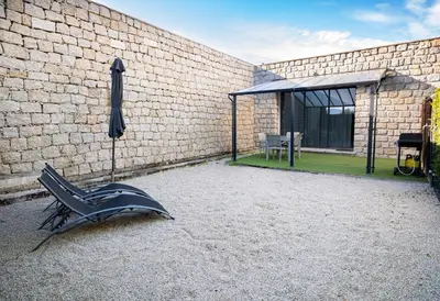 a chair sitting in front of a brick building at N1 Maison T2 climatisé in Ajaccio
