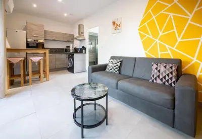 a living room with a couch and a table at N1 Maison T2 climatisé in Ajaccio