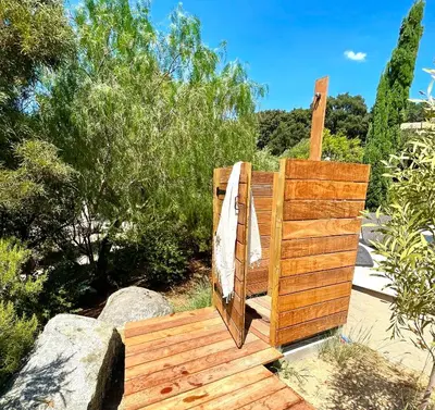 a wooden bench sitting on top of a wooden deck at Villa Terra Vecchia, 6 ou 12 personnes, vue imprenable, piscine chauffée in Porto-Vecchio