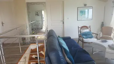 a living room with a blue couch and a staircase at Casa Elena in Ajola