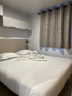 a white bed with two towels on top of it at Les collines de lava in Appietto
