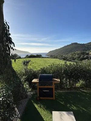a picnic table with a laptop on top of a field at Les collines de lava in Appietto