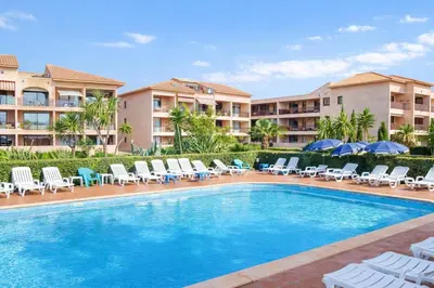 a swimming pool with chairs and umbrellas in a resort at Le Cocon de Lilie in San-Nicolao