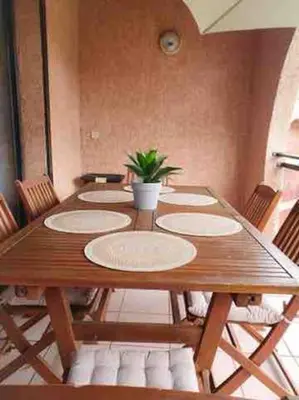 a long wooden table with chairs and a potted plant on it at Le Cocon de Lilie in San-Nicolao