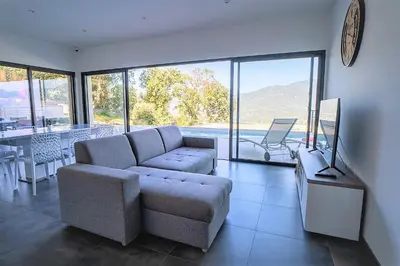a living room with a couch and a table at Villa Elora vue mer et piscine in Viggianello