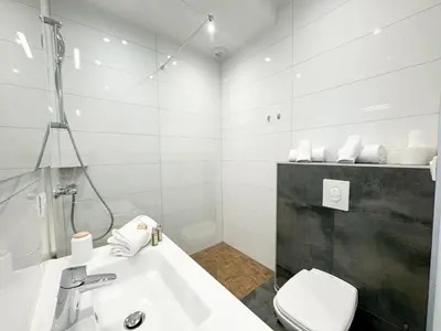 a white bathroom with a sink and a toilet at Villa Elora vue mer et piscine in Viggianello