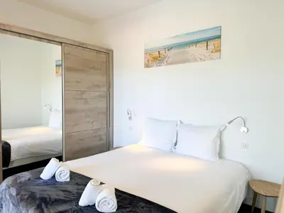 a bedroom with a large bed and a mirror at Villa Elora vue mer et piscine in Viggianello