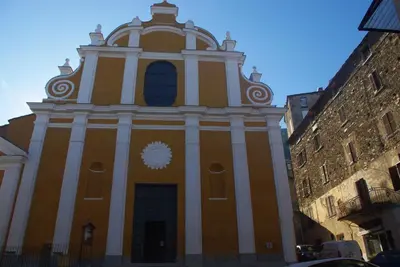 a large orange and white building with a clock on it at Résidence A NUCIOLA Les pieds dans l'eau Cervione Hte CORSE in Cervione