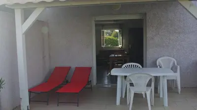 a table and chairs with a white table and red seats at Résidence A NUCIOLA Les pieds dans l'eau Cervione Hte CORSE in Cervione