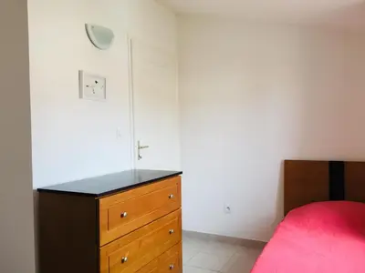 a bedroom with a wooden dresser and a bed at Résidence A NUCIOLA Les pieds dans l'eau Cervione Hte CORSE in Cervione