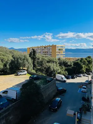 a parking lot with cars parked in front of a building at Charmant studio Sanguinaires in Ajaccio