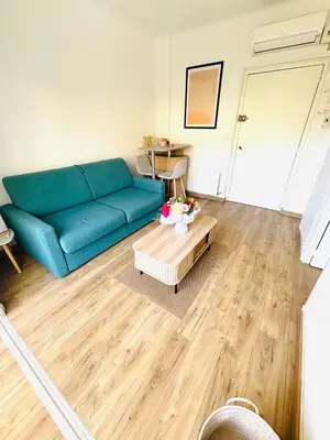 a living room with a blue couch and a coffee table at Charmant studio Sanguinaires in Ajaccio