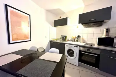 a kitchen with a washing machine and a table at Charming 45m in Sarrola carcopino in Sarrola-Carcopino