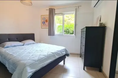a bedroom with a bed and a window and a dresser at Charming 45m in Sarrola carcopino in Sarrola-Carcopino