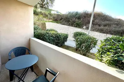 a table and chairs on a balcony with a view at Charming 45m in Sarrola carcopino in Sarrola-Carcopino