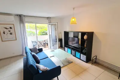 a living room with a blue couch and a tv at Charming 45m in Sarrola carcopino in Sarrola-Carcopino