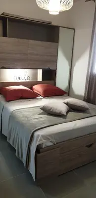 a bedroom with a large bed with red pillows at A 700m de la plage,villa FAMIGLIA avec piscine in Santa-Lucia-di-Moriani