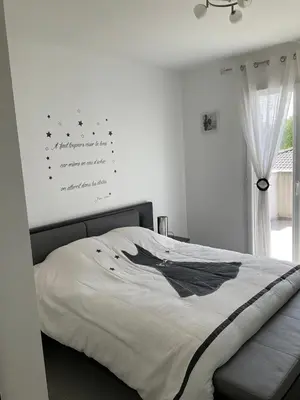 a white bedroom with a bed with a sign on the wall at A 700m de la plage,villa FAMIGLIA avec piscine in Santa-Lucia-di-Moriani