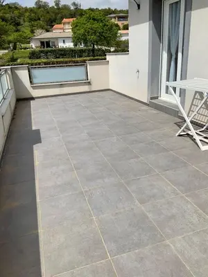 a tile patio with a table and a chair on a balcony at A 700m de la plage,villa FAMIGLIA avec piscine in Santa-Lucia-di-Moriani