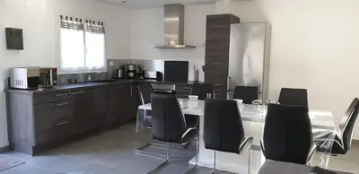 a kitchen with a table and black chairs in it at A 700m de la plage,villa FAMIGLIA avec piscine in Santa-Lucia-di-Moriani