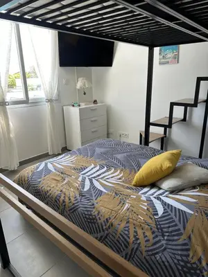 a bedroom with a bed with a yellow pillow on it at A 700m de la plage,villa FAMIGLIA avec piscine in Santa-Lucia-di-Moriani