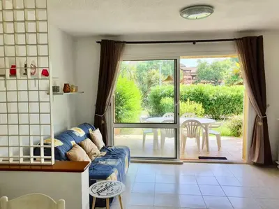 a living room with a couch and a sliding glass door at Un vrai petit bonheur en bord de mer - 6 pers. in Ghisonaccia