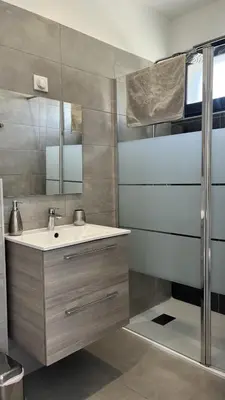 a bathroom with a sink and a mirror at N2 Maison T2 climatisé in Ajaccio