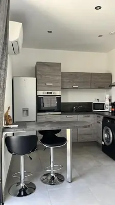 a kitchen with two bar stools and a counter at N2 Maison T2 climatisé in Ajaccio