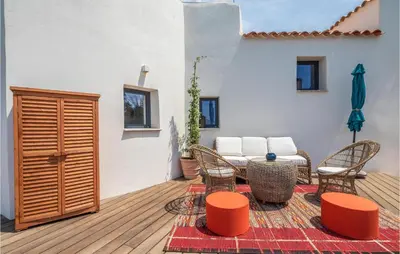 a patio with a table and chairs on a deck at Lovely Home In Porticcio in Porticcio