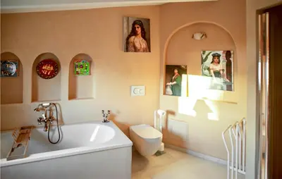 a bathroom with a tub and a toilet and pictures on the wall at Lovely Home In Porticcio in Porticcio