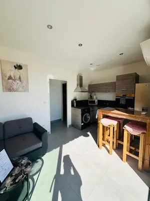 a kitchen and living room with a couch and a table at N3 Maison T2 climatisé in Ajaccio