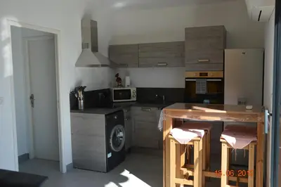 a kitchen with a washing machine and a microwave at N3 Maison T2 climatisé in Ajaccio