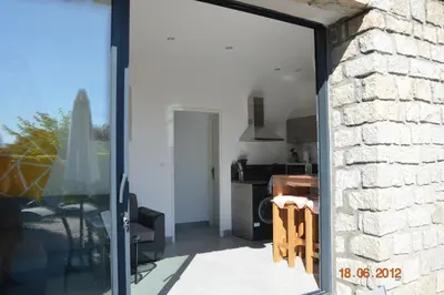 a room with a glass door leading to a kitchen at N3 Maison T2 climatisé in Ajaccio