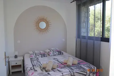 a bedroom with a bed and a mirror on the wall at N3 Maison T2 climatisé in Ajaccio