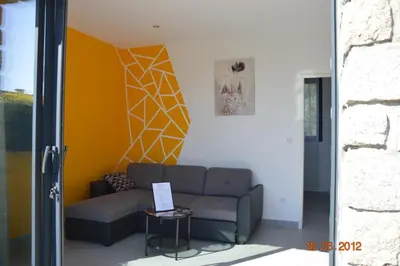 a living room with a couch and a wall at N3 Maison T2 climatisé in Ajaccio