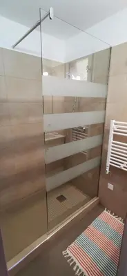 a shower with a glass door and a rug at Résidence de tourisme Les Hauts de l'Avena in Sartène