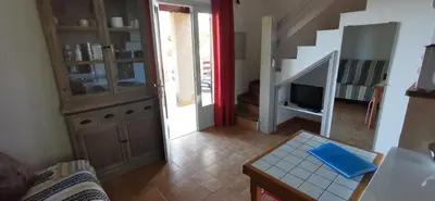 a living room with a couch and a table and a television at Résidence de tourisme Les Hauts de l'Avena in Sartène