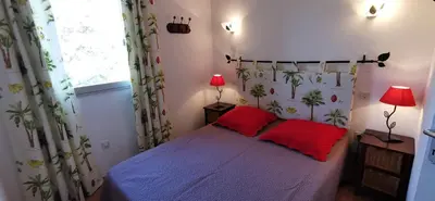 a bedroom with a bed with two red pillows at Résidence de tourisme Les Hauts de l'Avena in Sartène