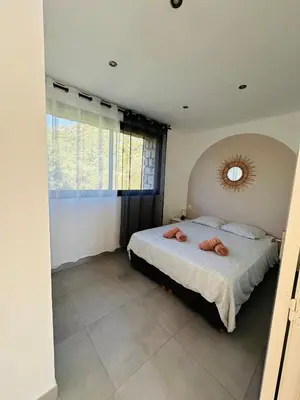 a bedroom with a bed and a mirror on the wall at N4 Maison T2 climatisé in Ajaccio