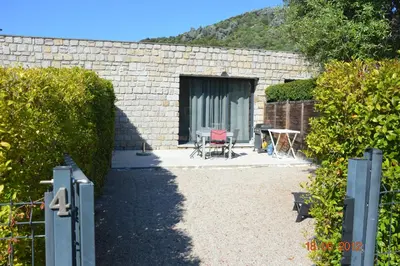 a brick building with a patio with a table and a chair at N4 Maison T2 climatisé in Ajaccio