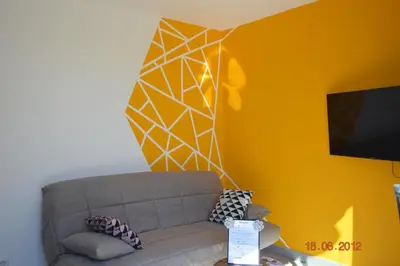 a living room with a couch and a yellow wall at N4 Maison T2 climatisé in Ajaccio