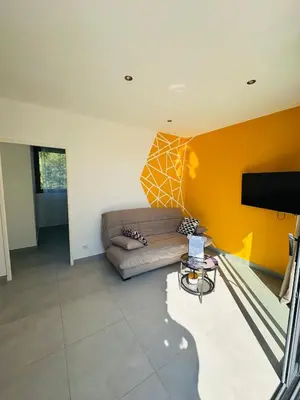 a living room with a couch and a tv at N4 Maison T2 climatisé in Ajaccio