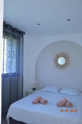 a bedroom with a bed with a mirror on the wall at N4 Maison T2 climatisé in Ajaccio